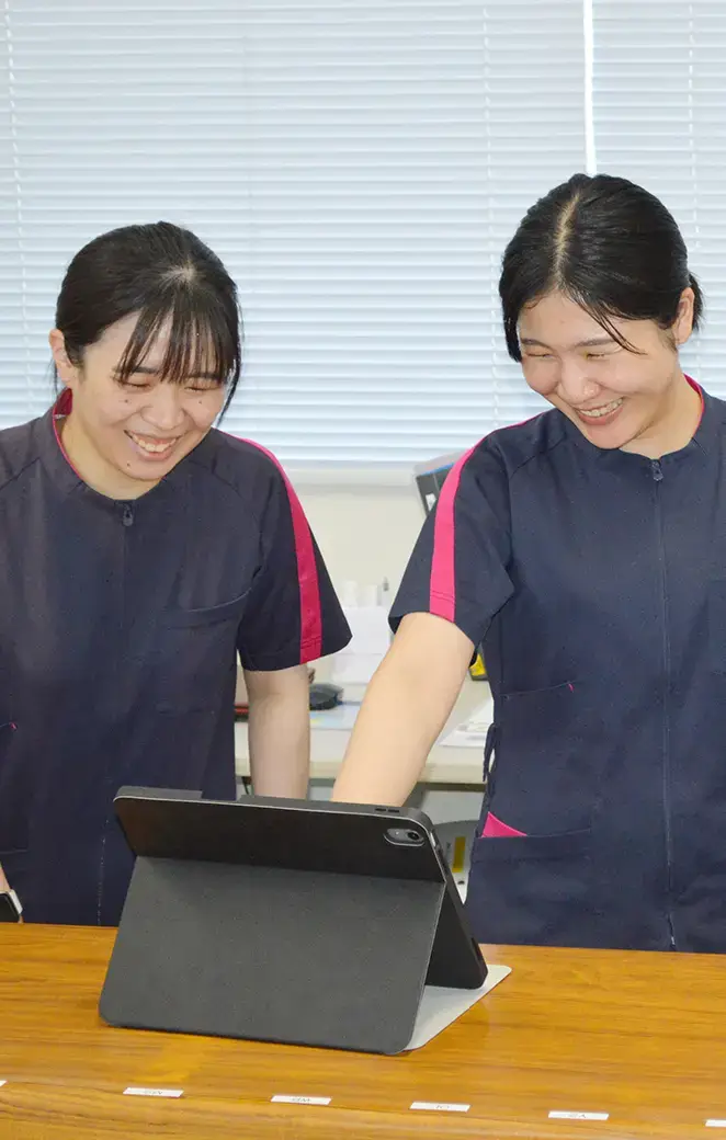 介護施設のスタッフ2名がタブレットを確認している様子